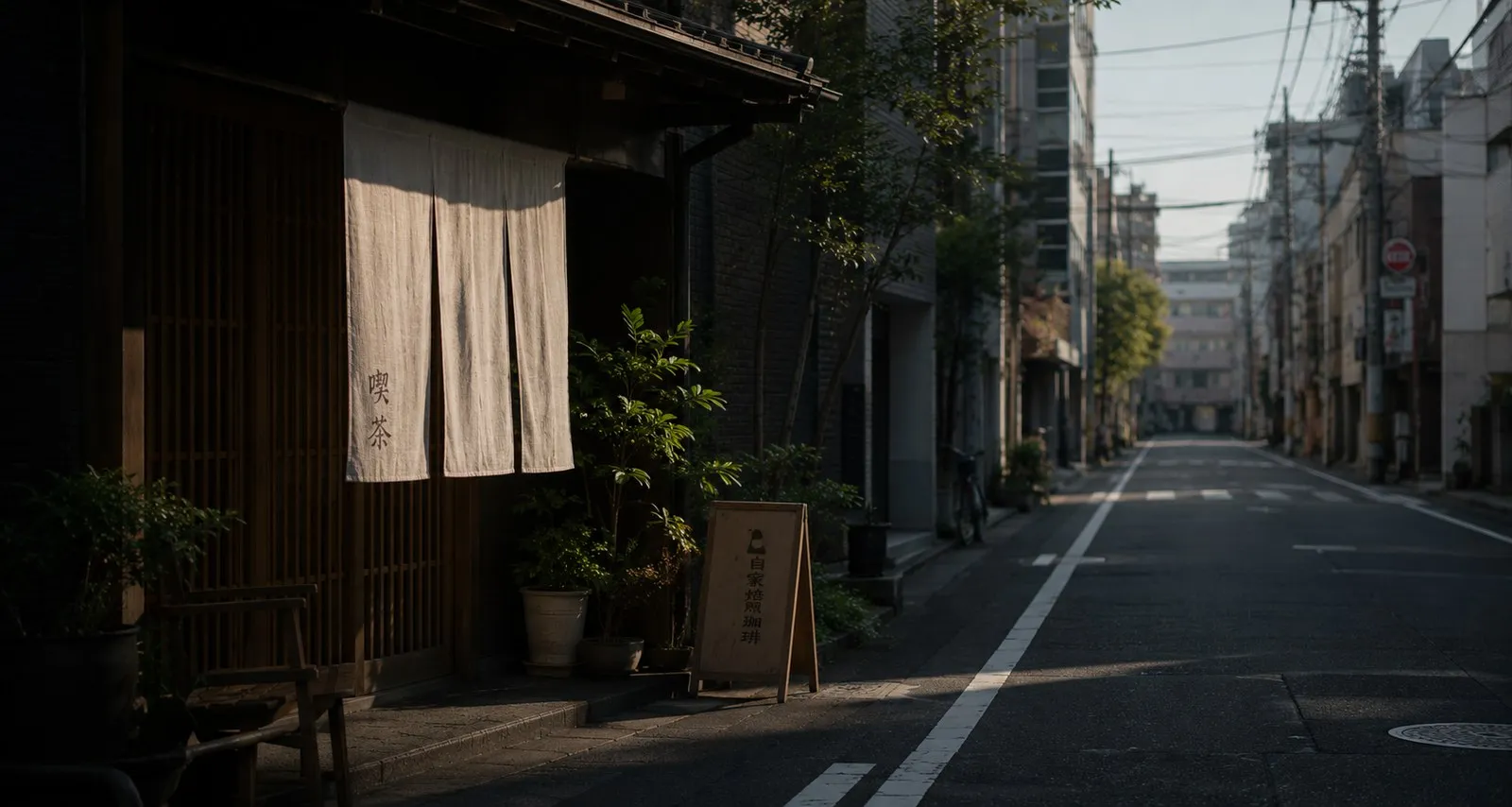Quiet Tokyo street in the early morning, noren hanging in front of a wooden facade.