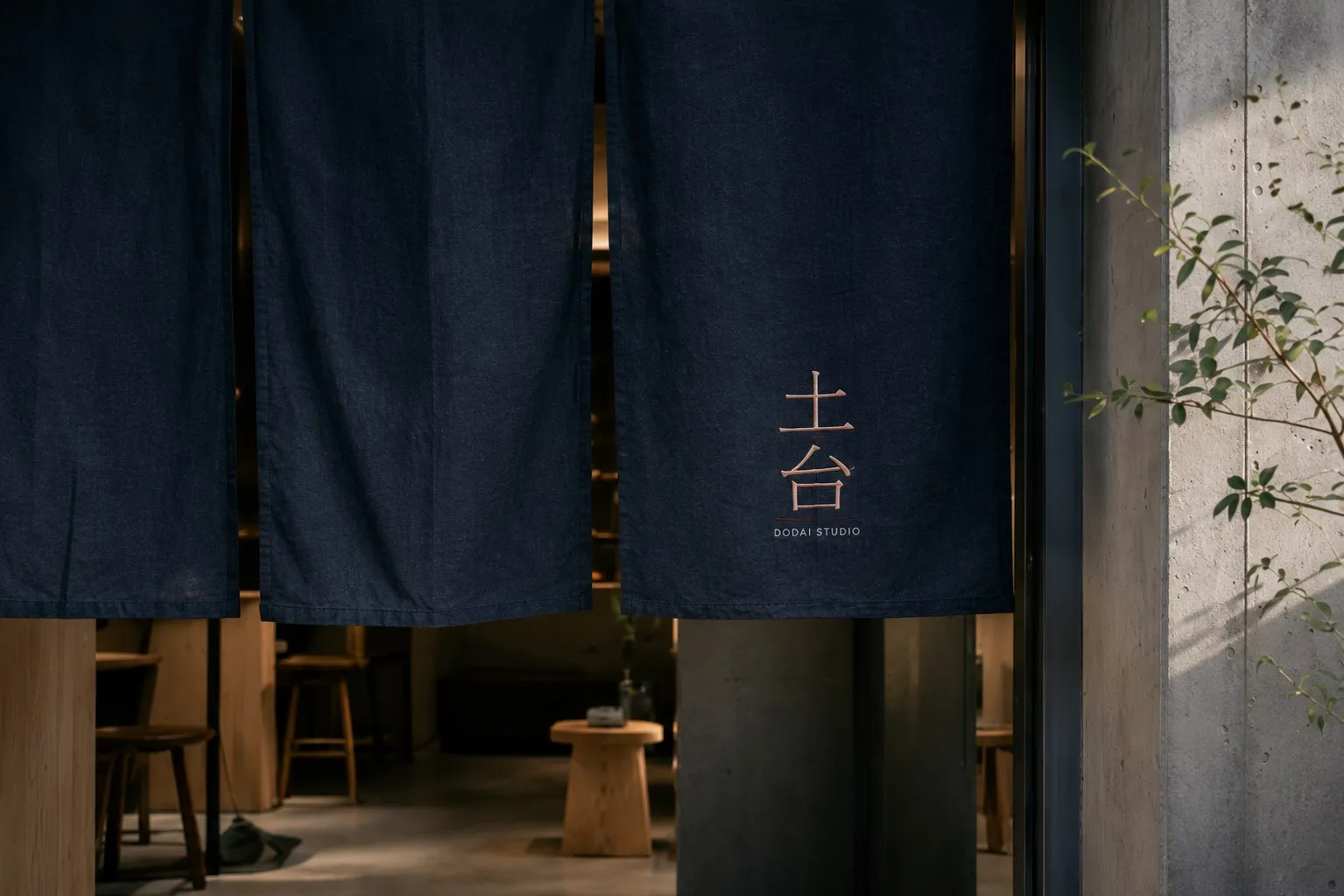 Noren marqué 土台 devant l'entrée d'un lieu à Tokyo, en fin de journée.